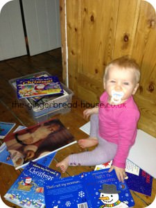 Baby surrounded by Christmas books