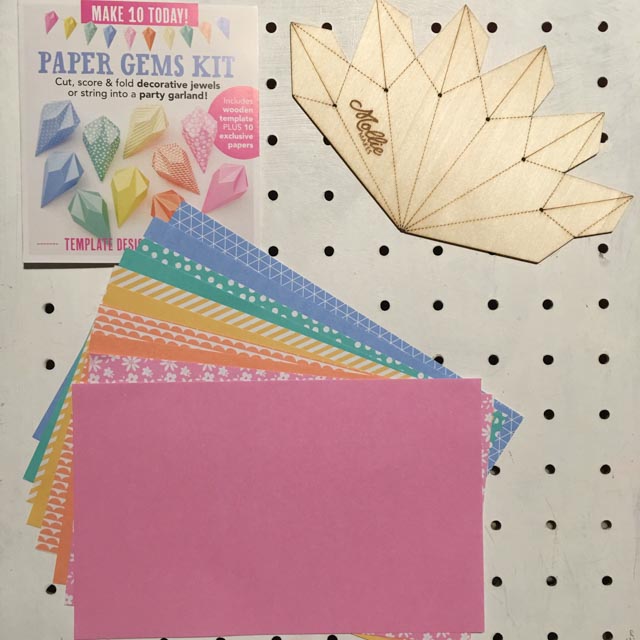 Mollie Makes Paper Gems Kit contents on a white peg board