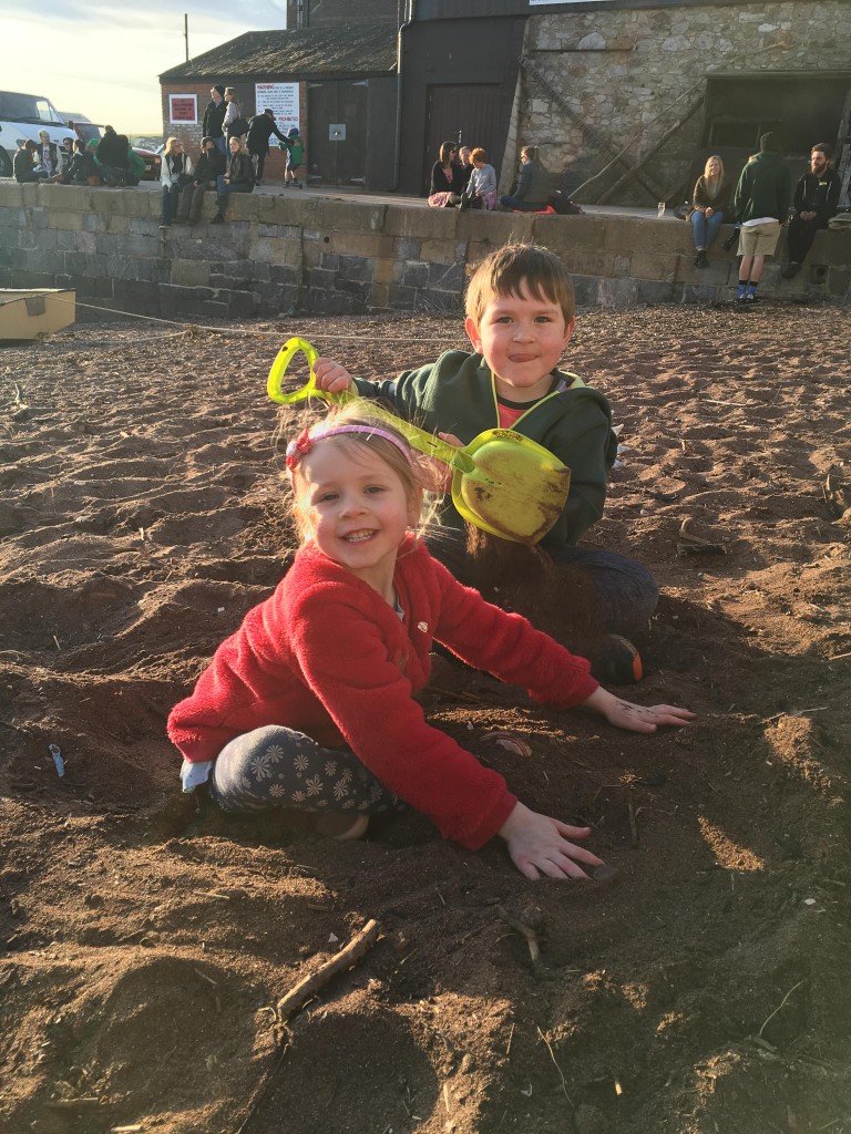 two children digging for treasure on the beach